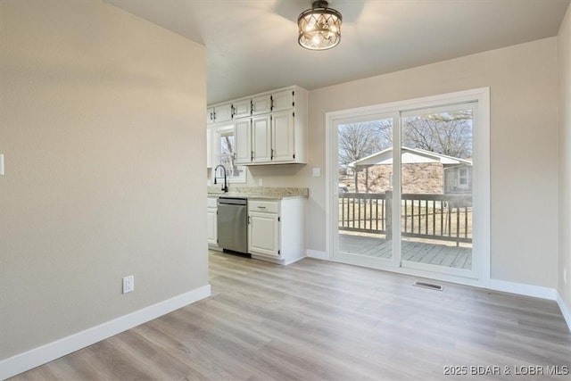 kitchen with visible vents, dishwasher, white cabinetry, and baseboards