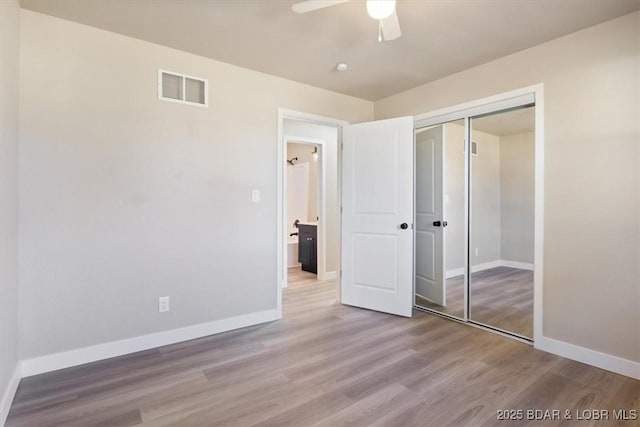 unfurnished bedroom with visible vents, baseboards, wood finished floors, a closet, and a ceiling fan