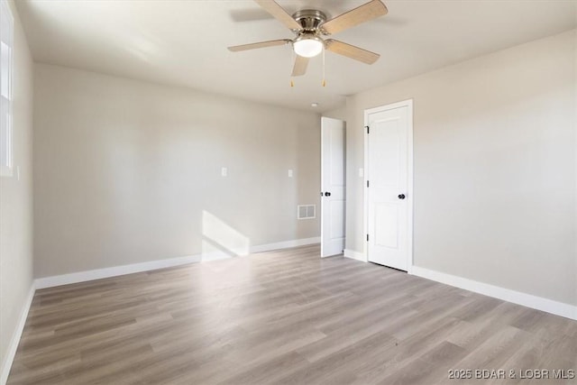 spare room featuring light wood-type flooring, baseboards, visible vents, and ceiling fan