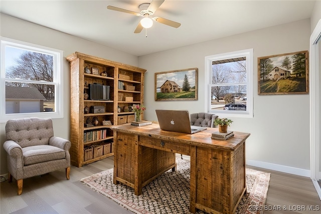 office space with a healthy amount of sunlight, baseboards, light wood-style floors, and ceiling fan