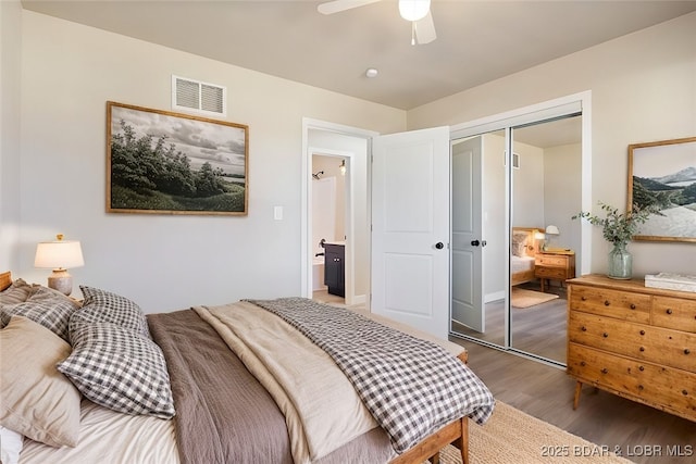 bedroom with visible vents, a closet, wood finished floors, and a ceiling fan