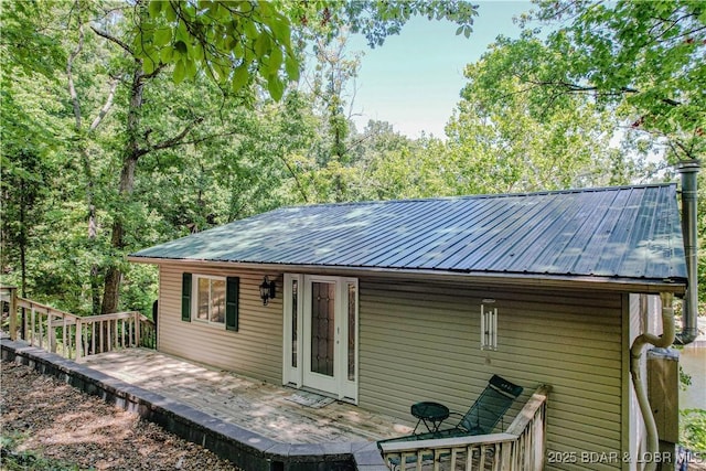 back of house with metal roof and a wooden deck