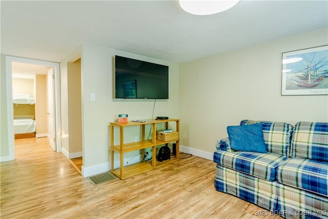 living area featuring light wood-style floors and baseboards