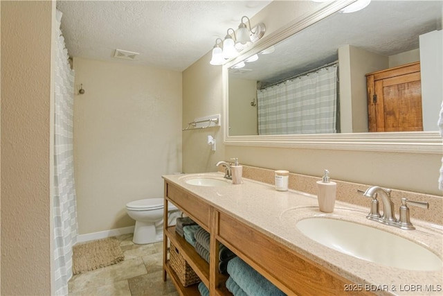 bathroom featuring a sink, a textured ceiling, and toilet