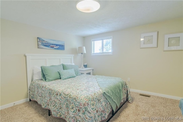 carpeted bedroom featuring visible vents and baseboards