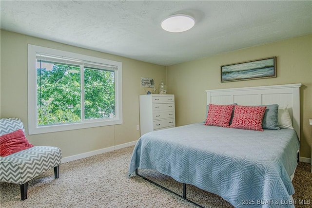 carpeted bedroom with a textured ceiling and baseboards