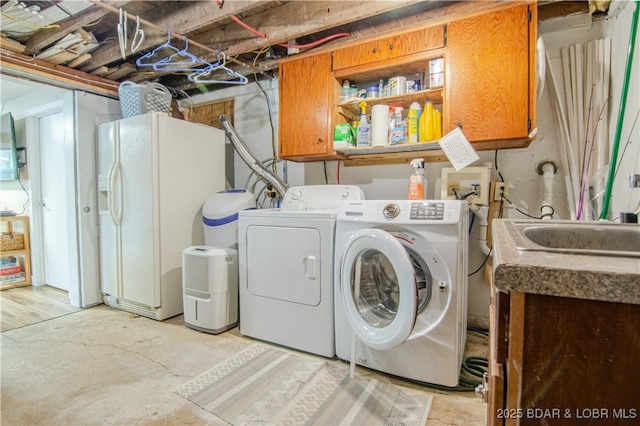 clothes washing area with cabinet space and washing machine and clothes dryer