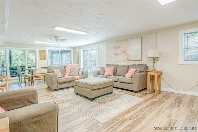 living area featuring plenty of natural light, a textured ceiling, and wood finished floors