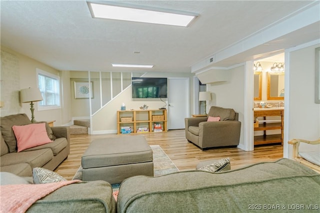 living room featuring stairs, wood finished floors, and baseboards