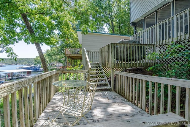 wooden deck featuring a water view and stairway