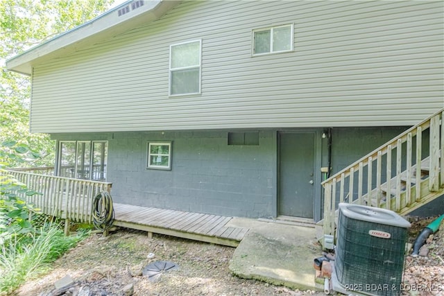 back of property with stairs and central AC