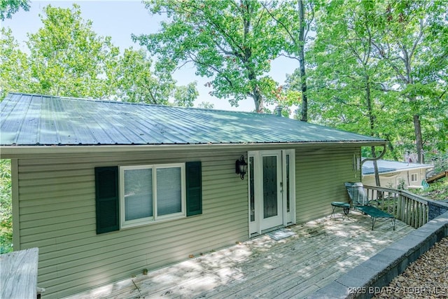 back of house featuring a deck and metal roof