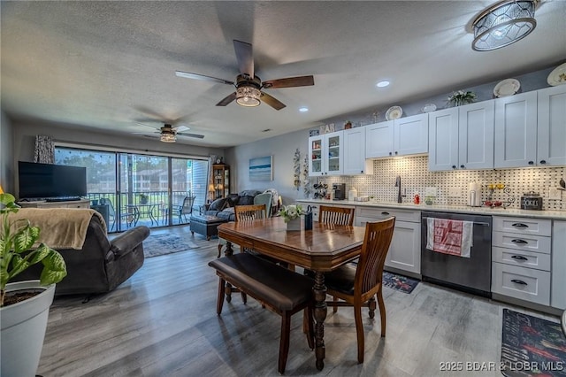 dining room featuring light wood finished floors, a ceiling fan, a textured ceiling, and recessed lighting