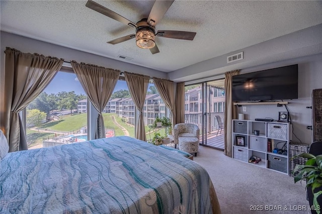 bedroom featuring carpet floors, access to outside, visible vents, and a textured ceiling