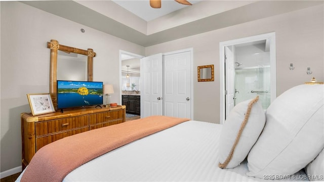 bedroom with ceiling fan, baseboards, and connected bathroom