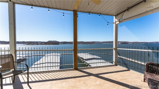 view of patio with a balcony and a water view