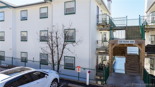 view of property with fence and stairs