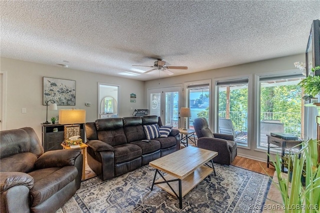 living room with a wealth of natural light, a textured ceiling, and wood finished floors