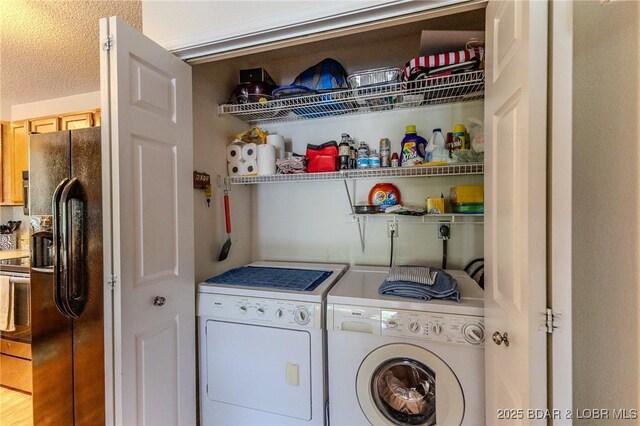 laundry room featuring laundry area, separate washer and dryer, and a textured ceiling