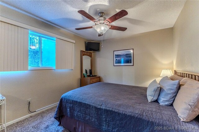 bedroom featuring a ceiling fan, carpet, a textured ceiling, and baseboards