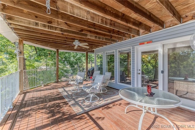 wooden terrace with outdoor dining space and ceiling fan