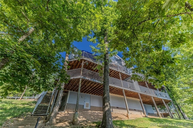 rear view of property featuring crawl space and stairway