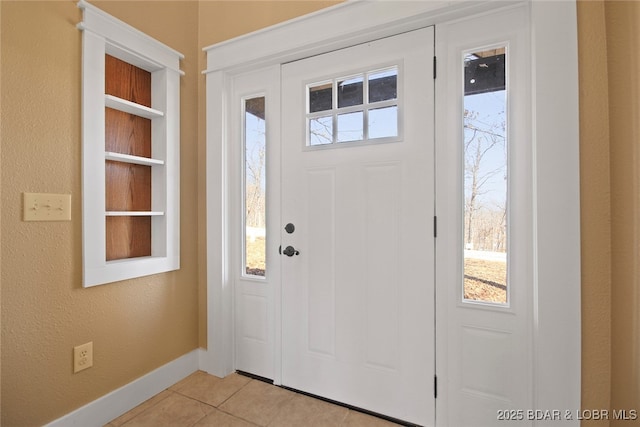 foyer with light tile patterned floors and baseboards