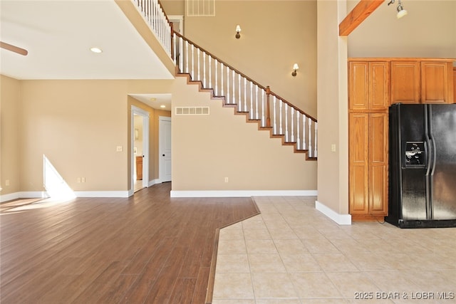 interior space featuring baseboards, visible vents, and black fridge