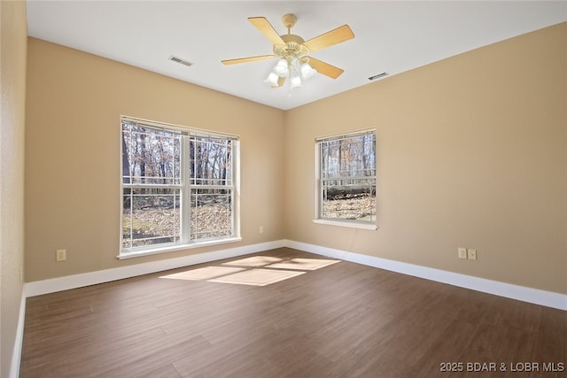 unfurnished room with baseboards, visible vents, ceiling fan, and wood finished floors