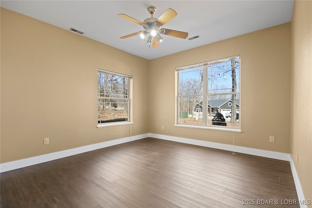 unfurnished room featuring visible vents, plenty of natural light, and wood finished floors