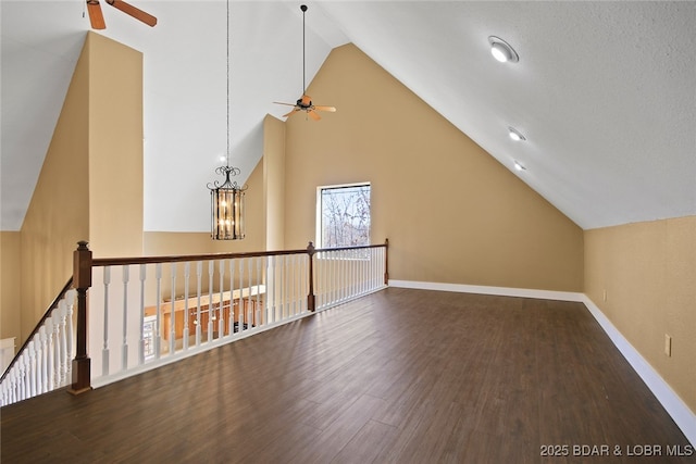 additional living space with high vaulted ceiling, ceiling fan with notable chandelier, baseboards, and wood finished floors