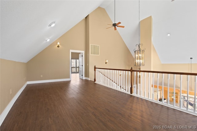 additional living space featuring visible vents, vaulted ceiling, wood finished floors, baseboards, and ceiling fan with notable chandelier