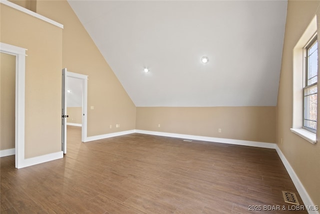 bonus room with visible vents, baseboards, vaulted ceiling, and wood finished floors