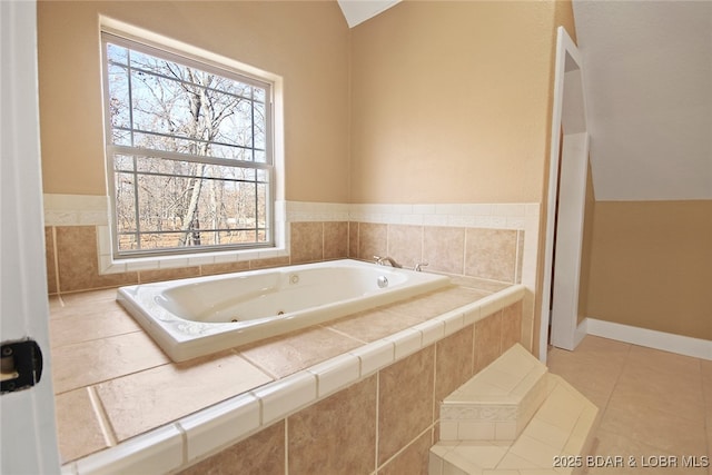 bathroom with tile patterned flooring, baseboards, vaulted ceiling, and a tub with jets