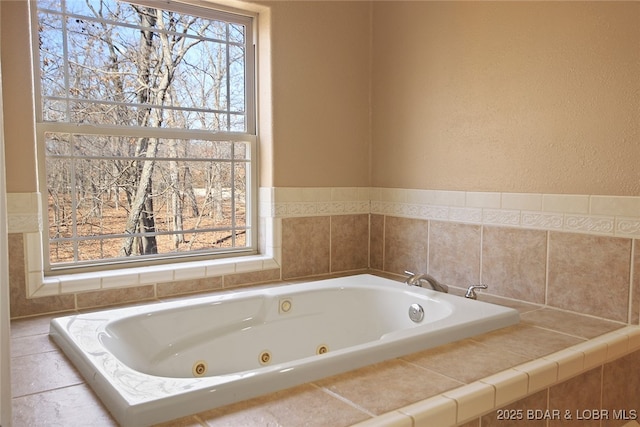 bathroom featuring a tub with jets and a wealth of natural light