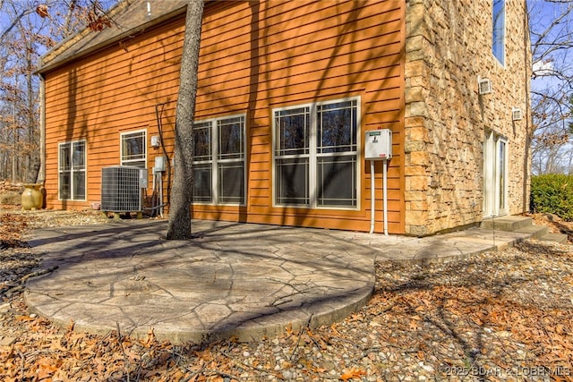 rear view of property with a patio area and central AC