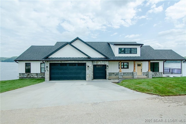 modern farmhouse style home featuring covered porch, an attached garage, board and batten siding, stone siding, and a front lawn