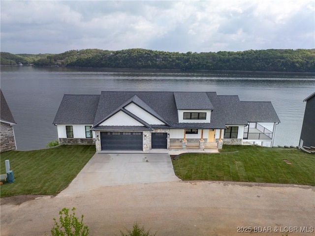 modern farmhouse style home featuring a front yard, an attached garage, and stone siding