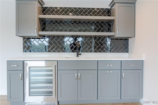 bar featuring wine cooler, a sink, and backsplash