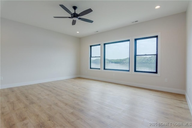 spare room featuring light wood-style flooring, visible vents, baseboards, and recessed lighting