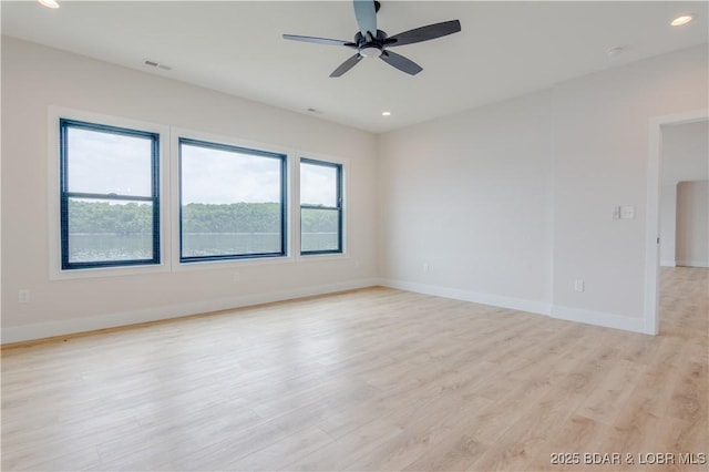 spare room featuring light wood finished floors, baseboards, visible vents, a ceiling fan, and recessed lighting