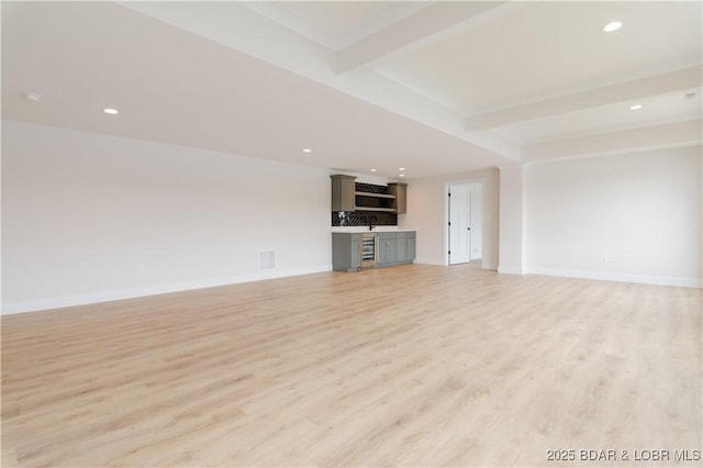 unfurnished living room featuring light wood-style flooring, recessed lighting, visible vents, baseboards, and beam ceiling