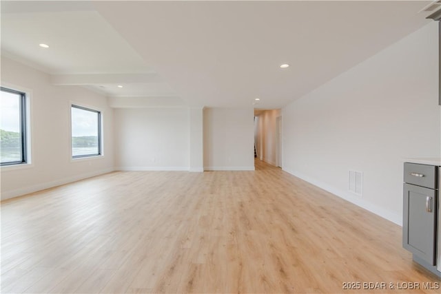 unfurnished living room featuring light wood-style floors, baseboards, visible vents, and recessed lighting