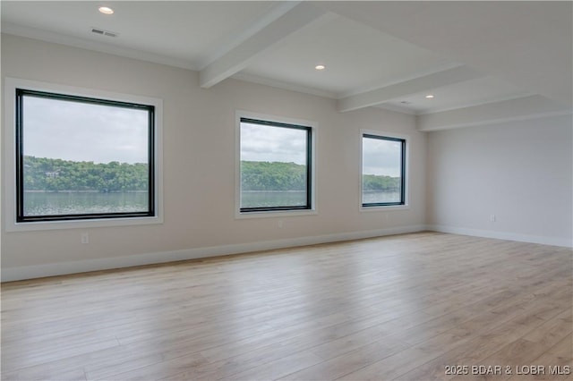 spare room with plenty of natural light, beamed ceiling, light wood-style flooring, and baseboards