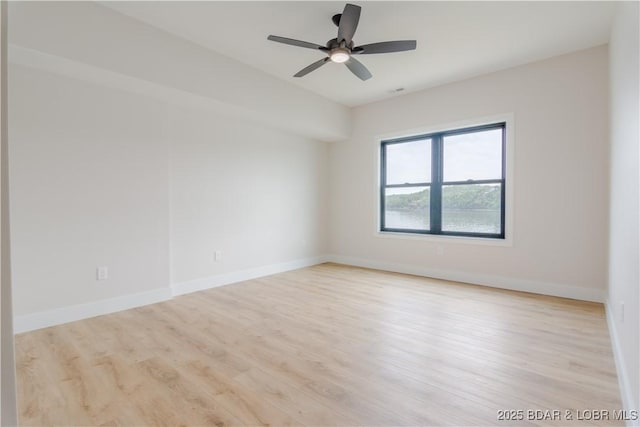 empty room with a ceiling fan, baseboards, and wood finished floors