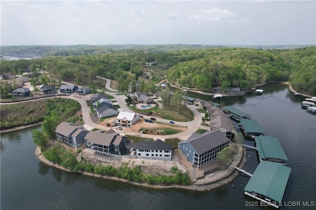 drone / aerial view featuring a water view and a wooded view