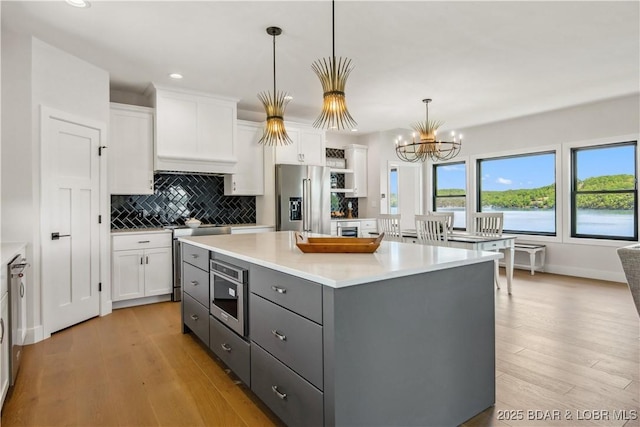 325 Mission Bay Dr, Camdenton, MO 65020 - kitchen with white cabinetry, stainless steel appliances, and light wood-style floors