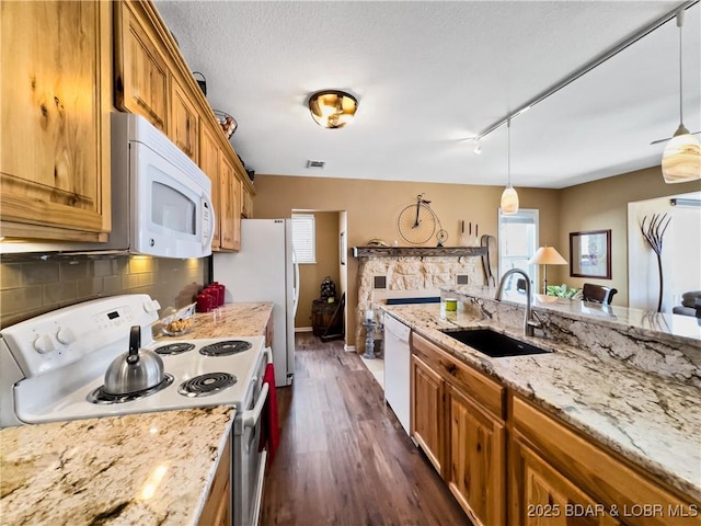 kitchen with brown cabinetry, white appliances, and a sink