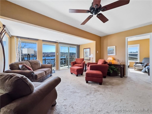 carpeted living room featuring a ceiling fan and a wealth of natural light