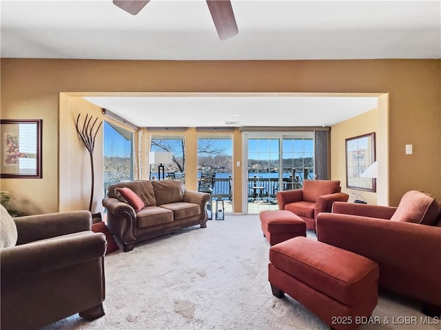 carpeted living room with a ceiling fan